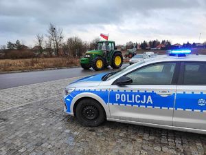 Radiowóz oznakowany i traktor na drodze