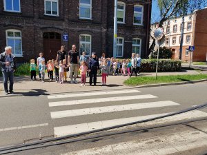 Dzieci i policjantka stoją przed przejściem dla pieszych