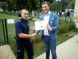 Zastępca Prezydenta Miasta Gdańska gratuluje policjantowi i wręcza mu certyfikat