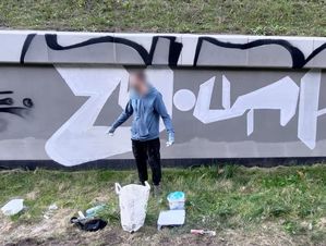 Mężczyzna stoi na tle muru z graffiti