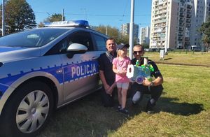 Policjanci z dzieckiem przy radiowozie