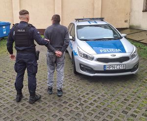 Policjant trzyma zatrzymanego mężczyznę