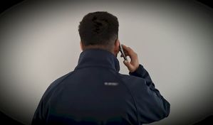 Mężczyzna stoi tyłem i rozmawia przez telefon
