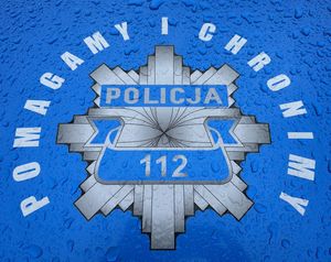 Policyjna gwiazda z napisem ,,Pomagamy i chronimy&#039;&#039; na niebieskim tle