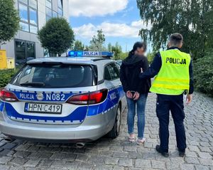 Radiowóz, policjant i zatrzymana kobieta