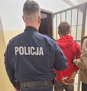 Policjant prowadzi zatrzymanego mężczyznę