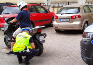 Policjant ruchu drogowego prowadzi kontrolę motocykla