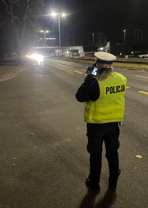 Policjant ruchu drogowego mierzy prędkość