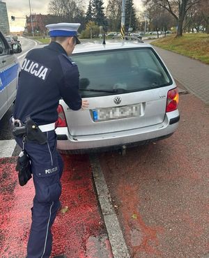 Policjant ruchu drogowego pcha samochód