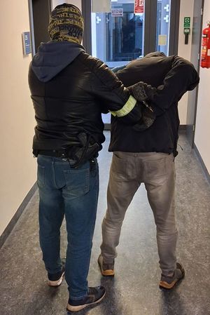 Kryminalny prowadzi zatrzymanego