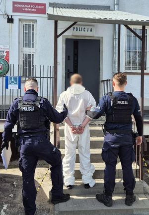 Policjanci prowadzą zatrzymanego
