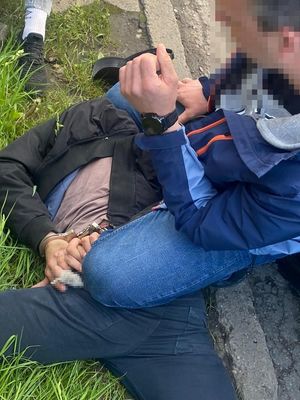 Policjant i leżący  zatrzymany mężczyzna