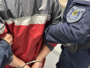 Policjanci prowadzą zatrzymanego