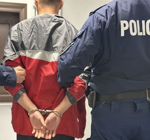 Policjanci prowadzą zatrzymanego
