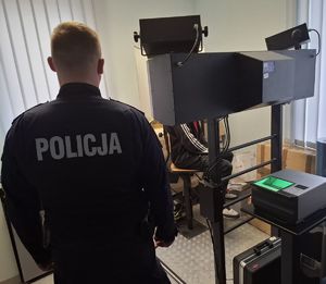 Policjant umundurowany stoi tyłem
