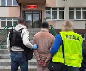Policjanci prowadzą zatrzymanego