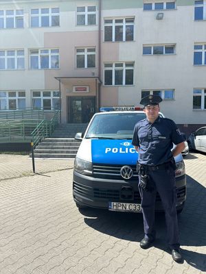 Niemiecki policjant przed radiowozem