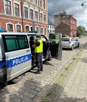Policjant, radiowóz i pojazd zatrzymany do kontroli