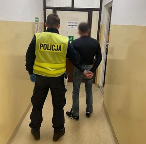 Policjant prowadzi zatrzymanego