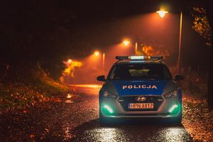 radiowóz oznakowany, w tle jesienne drzewa