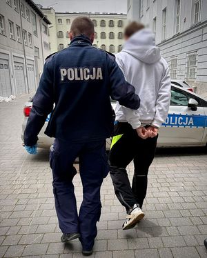 Policjant prowadzi zatrzymanego