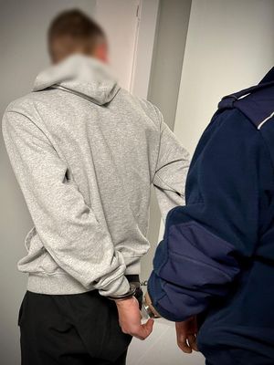 Policjanci prowadzą zatrzymanego