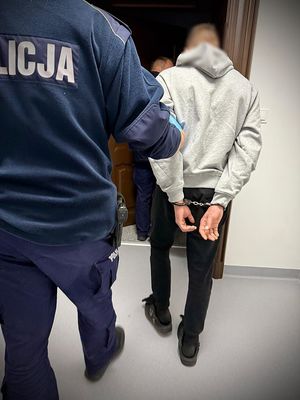 Policjanci prowadzą zatrzymanego