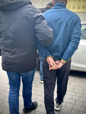 Kryminalny prowadzi zatrzymanego