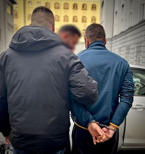 Kryminalny prowadzi zatrzymanego