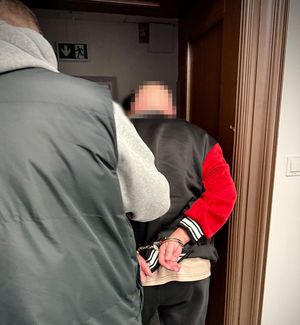 Policjant prowadzi zatrzymanego