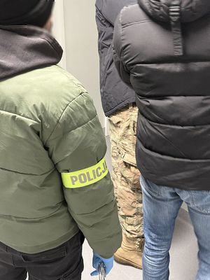 Policjant prowadzi zatrzymanego