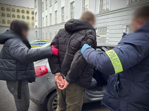 Policjanci prowadzą zatrzymanego