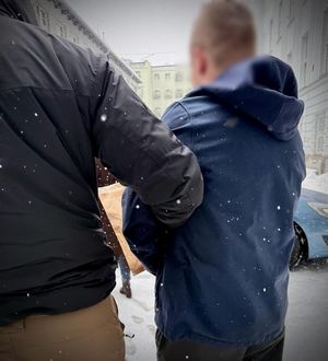 Policjant prowadzi zatrzymanego