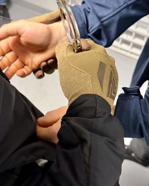 Policjant zakłada kajdanki na ręce z przodu