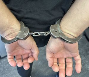 Kajdanki na rekach założonych z tyłu.