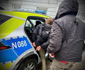 Zatrzymana prowadzona przez funkcjonariuszy.