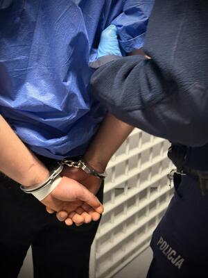 Policjant prowadzi zatrzymanego