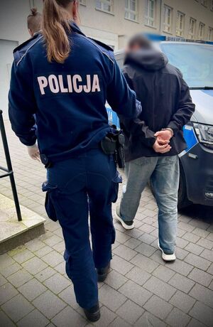 Policjanci prowadzą zatrzymanego mężczyznę