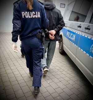 Policjanci prowadzą zatrzymanego mężczyznę
